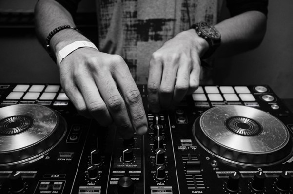 A DJ uses a basic controller for mixing tracks.
